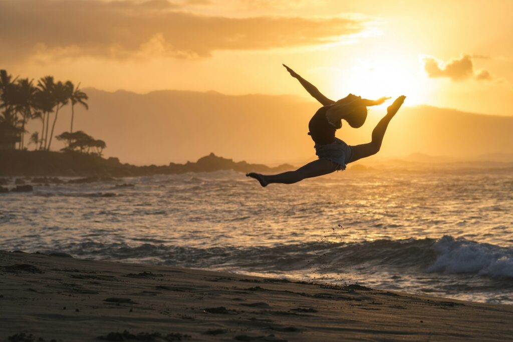 silhouette of woman jumping on sea shore